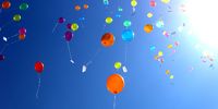 Bunte Luftballons, die in den sonnigen Himmel aufsteigen